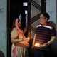 Residents stand with candles in their doorway in New Delhi.